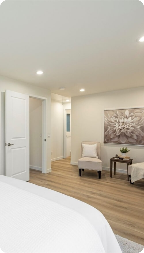 A cozy bedroom design with warm lighting, wooden flooring, and elegant decor.